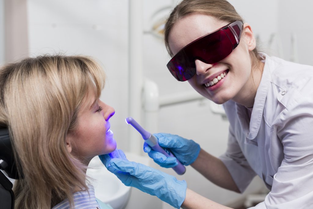 dentist performing teeth whitening 1