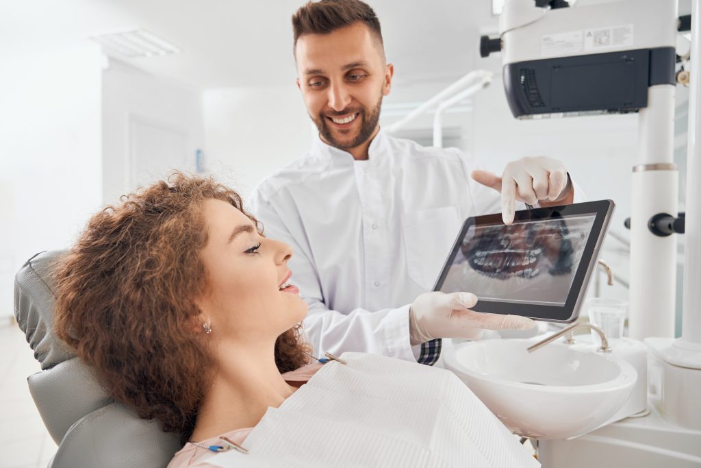 male doctor showing xray pictures teeth tablet